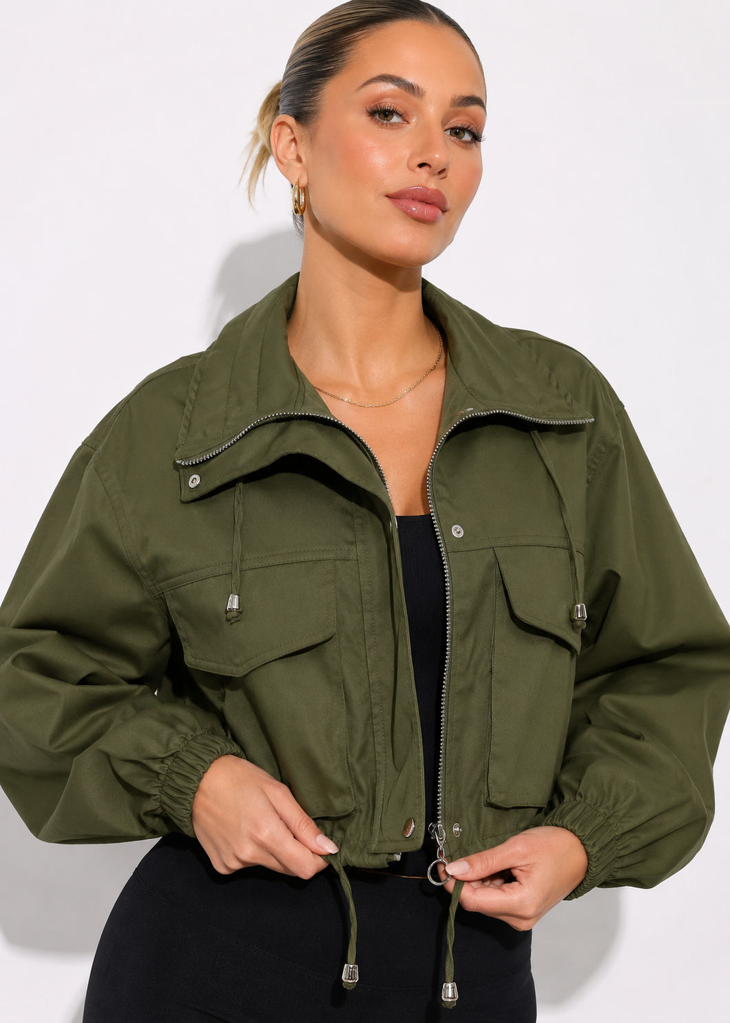 Woman wearing an olive green jacket against a white background