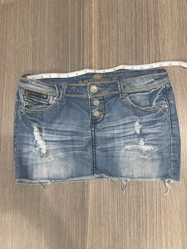 Almost Famous distressed denim micro mini skirt, front view with tape measure across waist