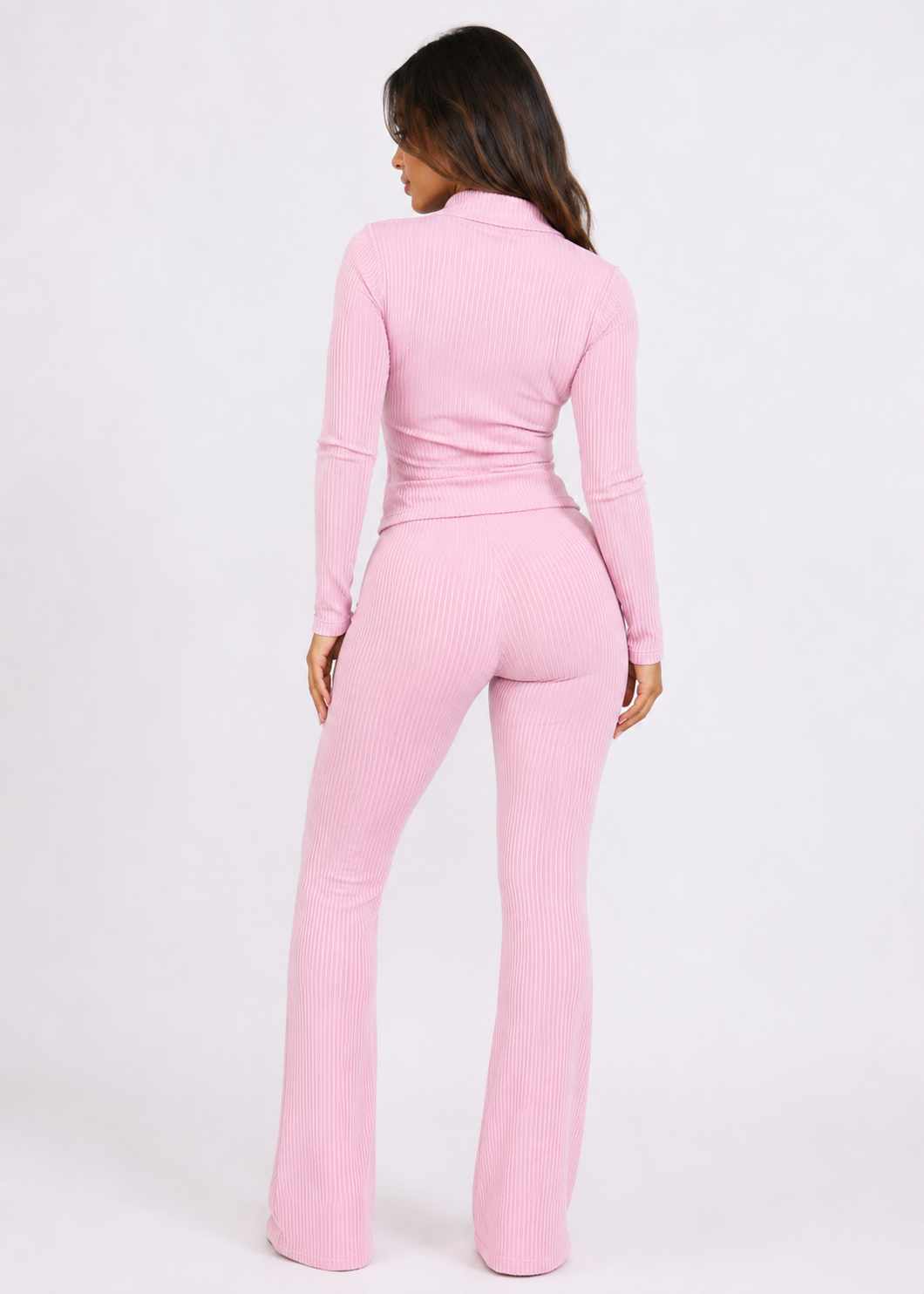 Model wearing Ulovmi pink ribbed zip-up top and flare pants set, back view