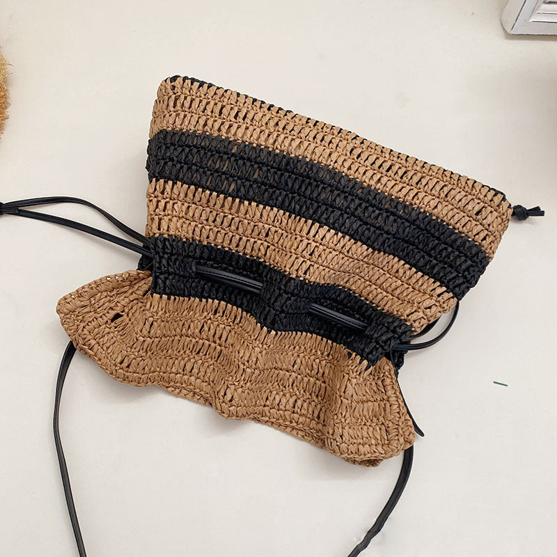 Calla black and tan striped woven straw drawstring bag on a vanity