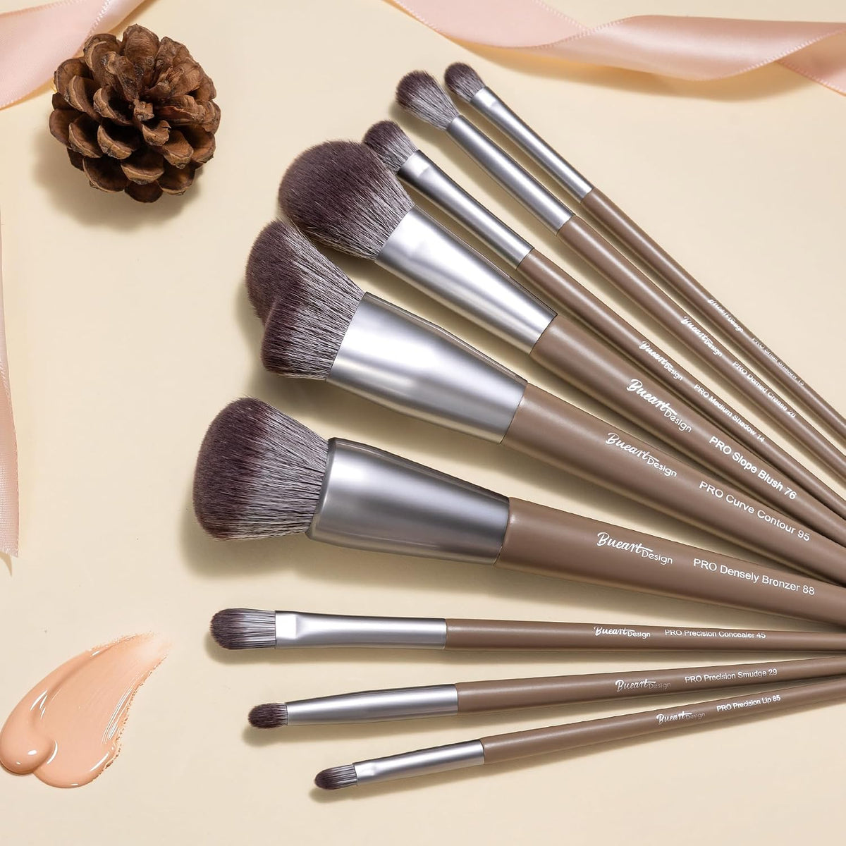 Close-up of Bueart Design chocolate makeup brushes fanned out with a foundation swatch