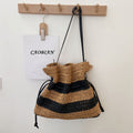 Calla black and tan striped woven shoulder bag hanging on a wall hook