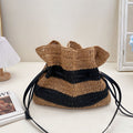 Calla black and tan striped woven straw drawstring bag on a vanity