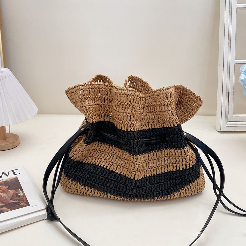 Calla black and tan striped woven straw drawstring bag on a vanity