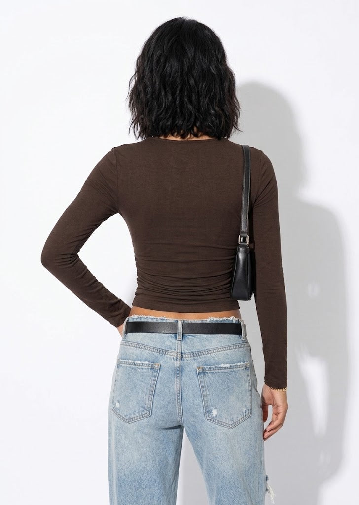 Calista brown one-shoulder buckle top with long sleeves, styled with light jeans