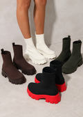 Four pairs of boots in different colors on a light gray background