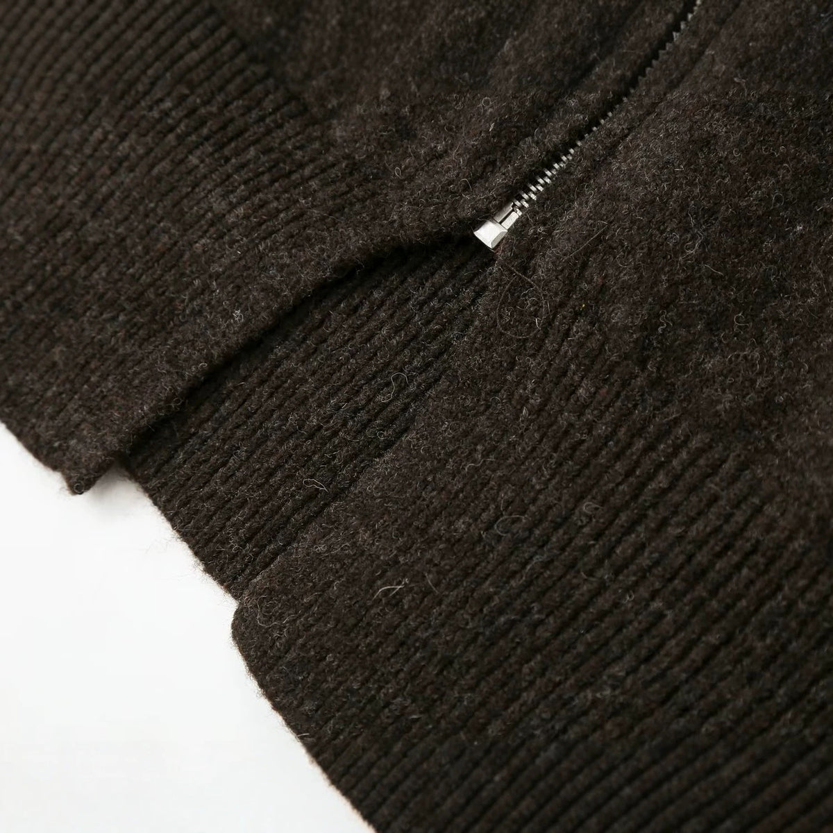 Detail of the zipper and ribbed hem on the Cecily dark brown knit cardigan