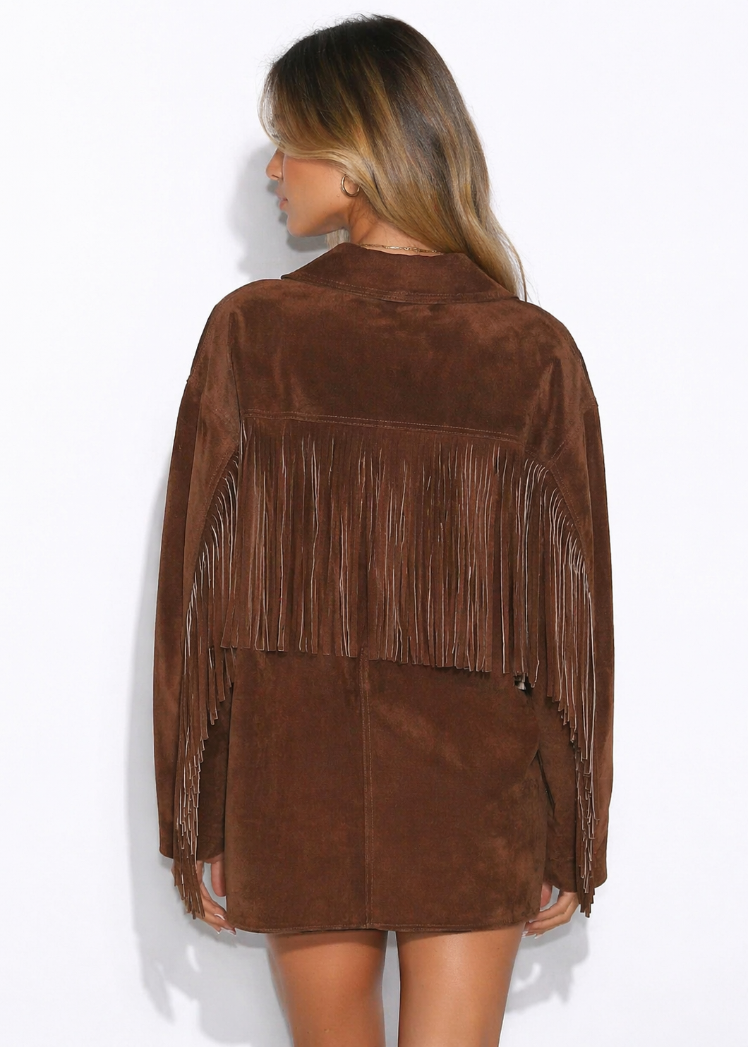 Woman wearing a brown suede jacket with fringe on a white background
