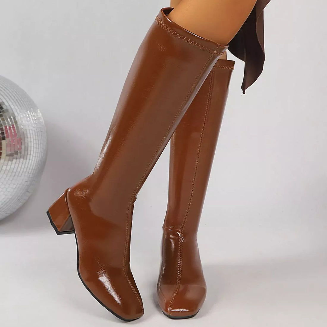Blythe square-toe knee-high block-heel boots in warm brown Khaki, modeled in a seated side view