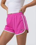 Model wearing Juicy Couture Sport 3-inch dolphin shorts in Fierce Love pink
