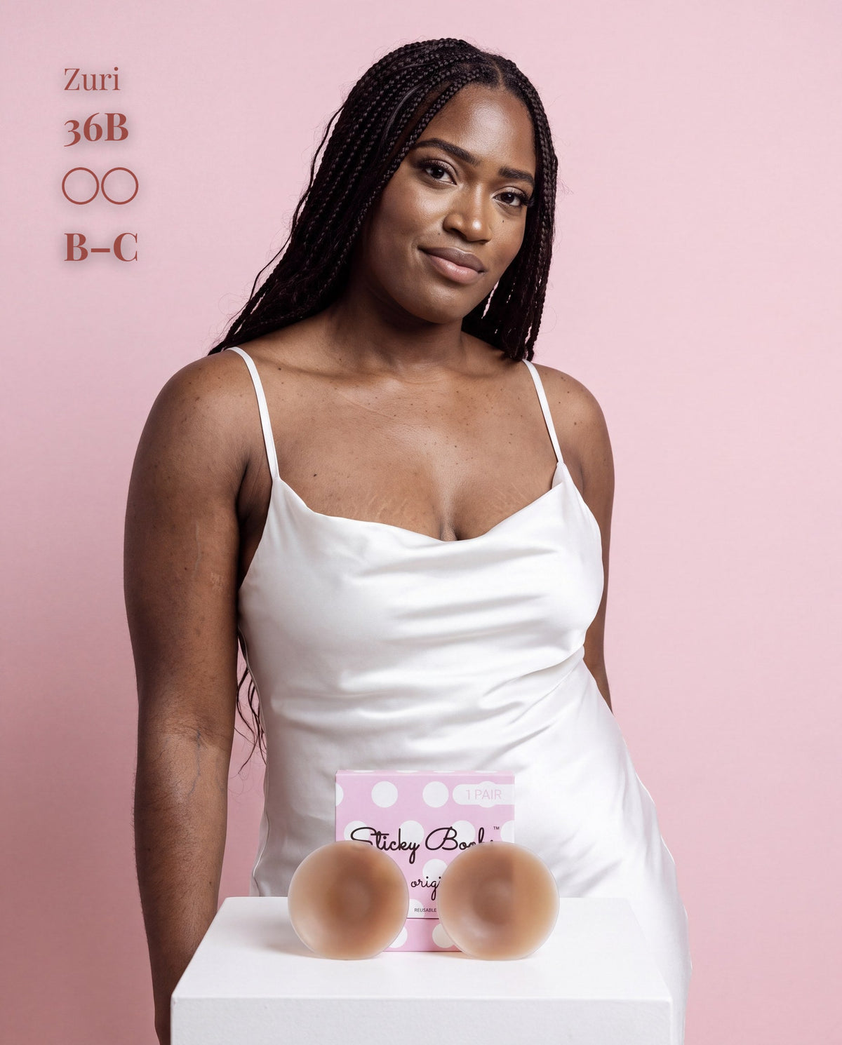 Model in a white satin slip with Sticky Boobs dark covers, cup size B-C