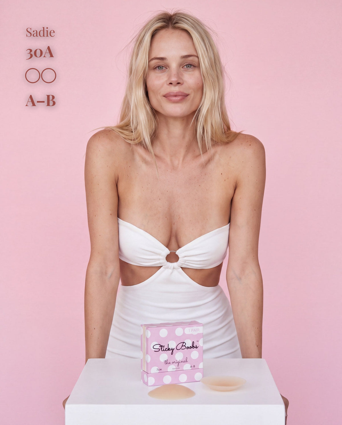 Model wearing a white cutout dress with Sticky Boobs nipple covers, size A-B