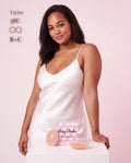 Model in a white satin dress with Sticky Boobs nipple covers, cup size B-C