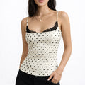 Woman wearing a white polka dot lace trim cami tank top