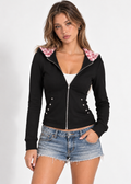 Roxie black zip-up hoodie with pink leopard hood lining, styled with denim shorts, front view