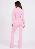 Model wearing Ulovmi pink ribbed zip-up top and flare pants set, back view