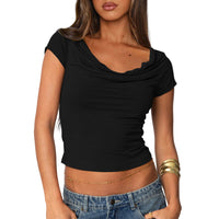 Woman wearing a black crop top and blue jeans on a light gray background